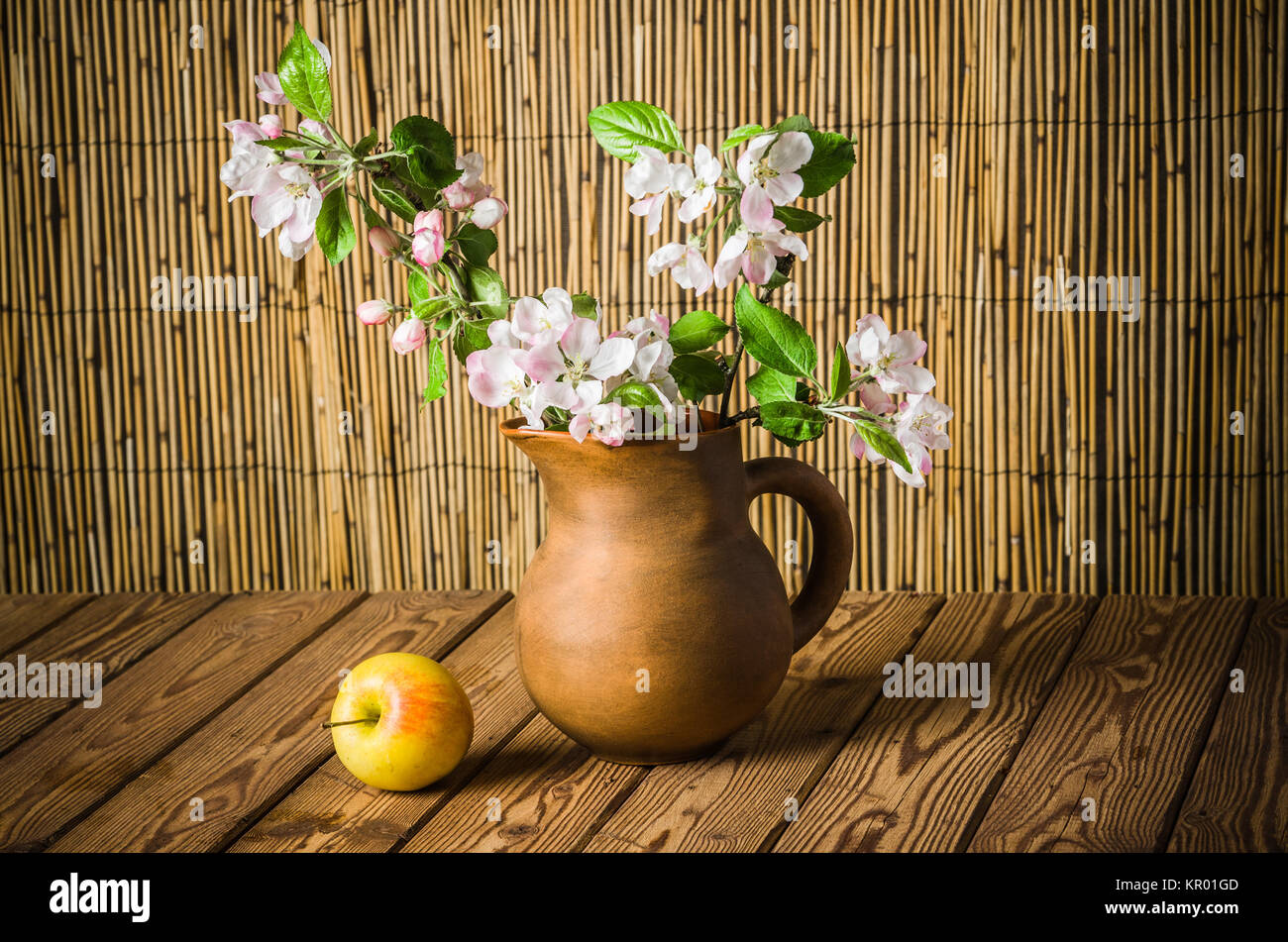 Reifer Apfel und blühenden Zweig von einem Apfelbaum in einem Ton-Glas, Nahaufnahme Stockfoto