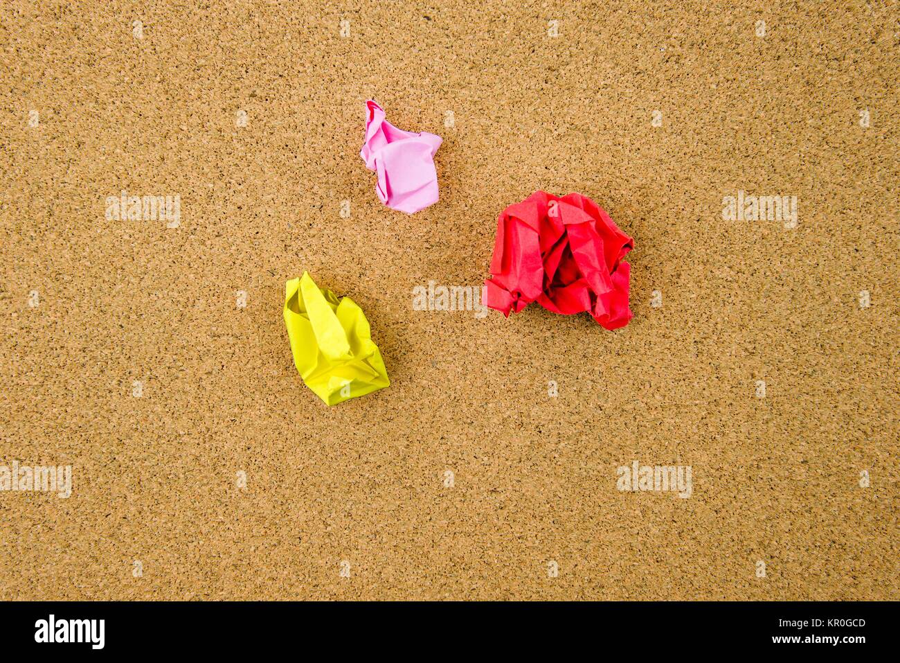 Bunte zerknitterten Papiere über Kork-Hintergrund Stockfoto