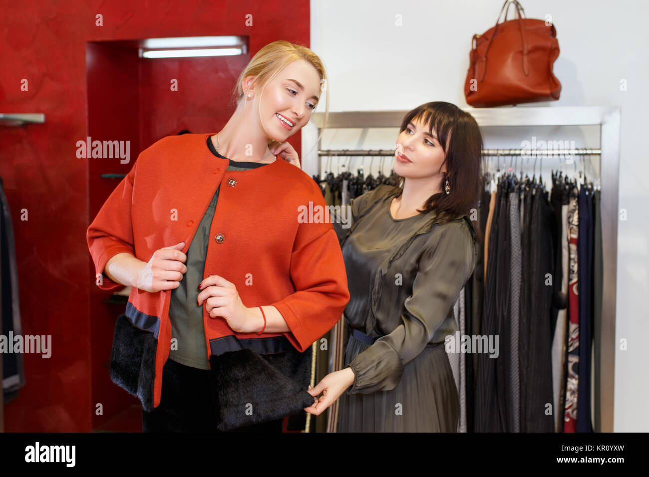 Sales Consultant helfen wählt Kleidung für den Kunden in der Filiale. Shopping mit Stylistin. Female Shop Assistant consulting junge Frau in der Fas Stockfoto