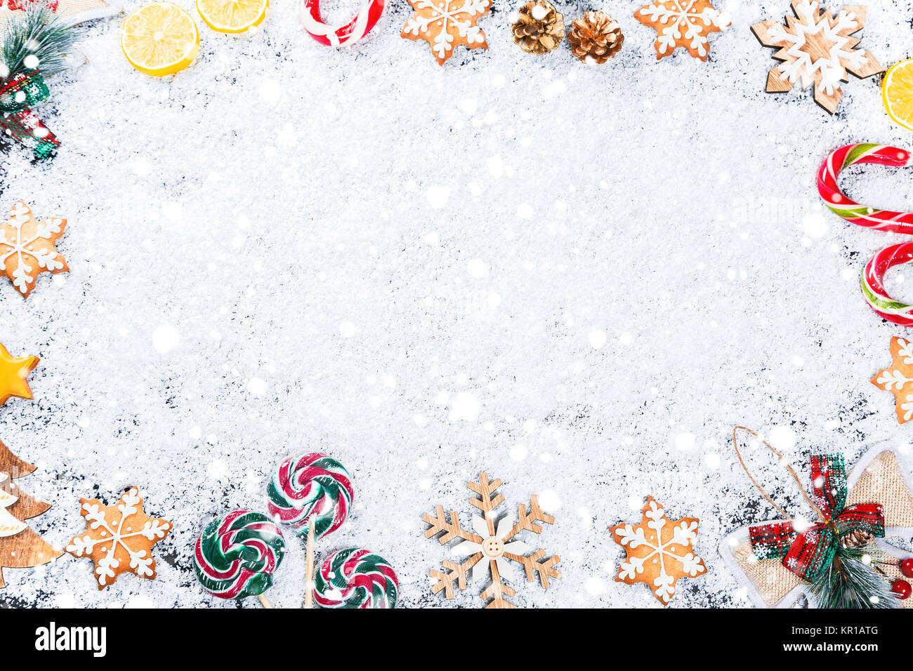 Weihnachten Hintergrund mit Lebkuchen Schneeflocken, weißer Schnee, Spielzeug, Zitrone, Süßigkeiten und Neues Jahr eingerichtet. Winterurlaub Frame auf einer schwarzen Holztisch Stockfoto