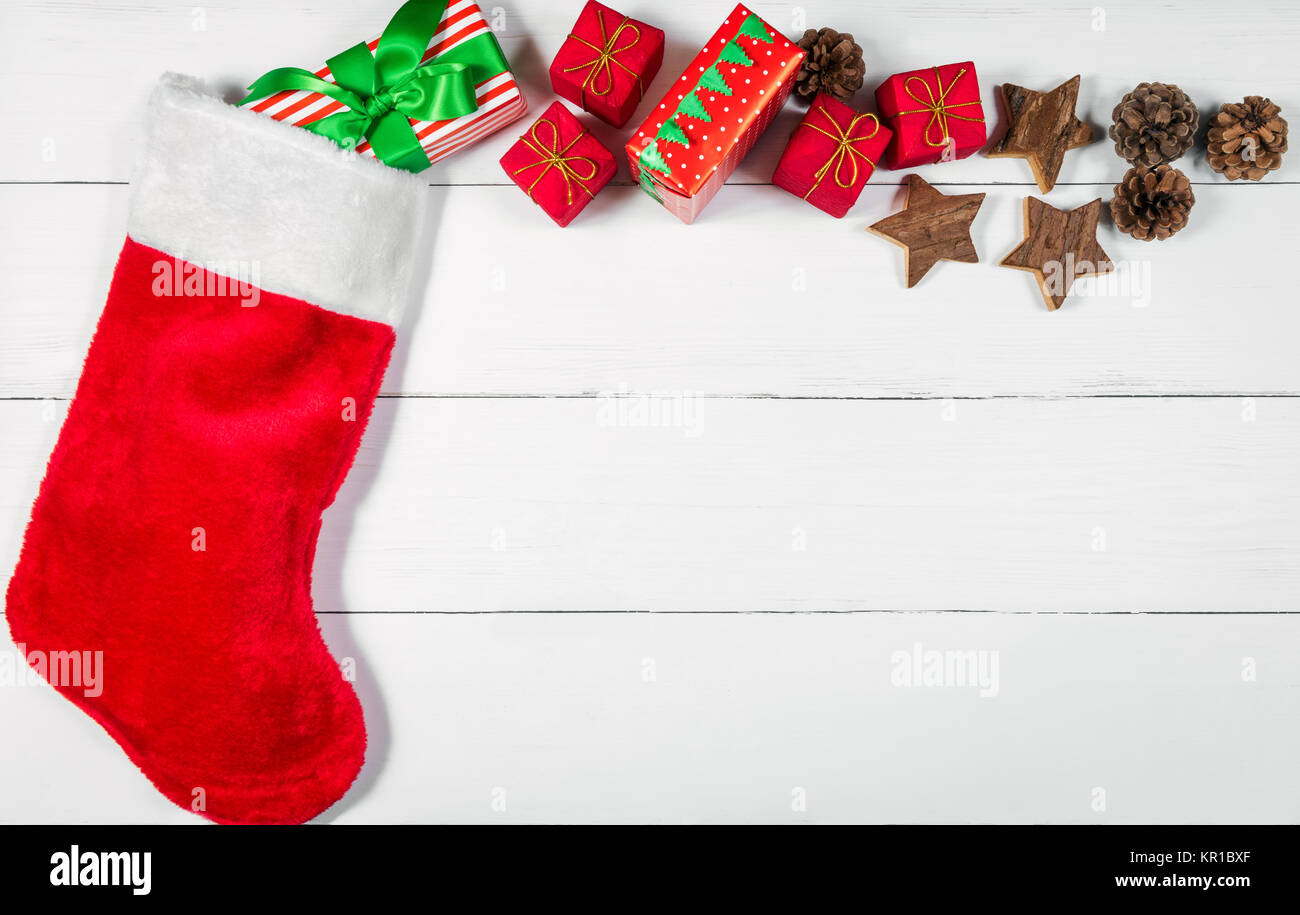 Weihnachtsstrumpf mit Geschenken und Ornamente Rolling Out Stockfoto
