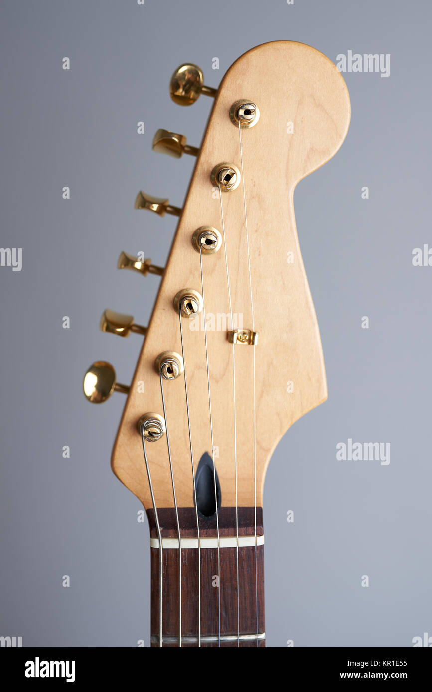 Kopfplatte E-Gitarre schließen bis auf grauem Hintergrund Stockfoto