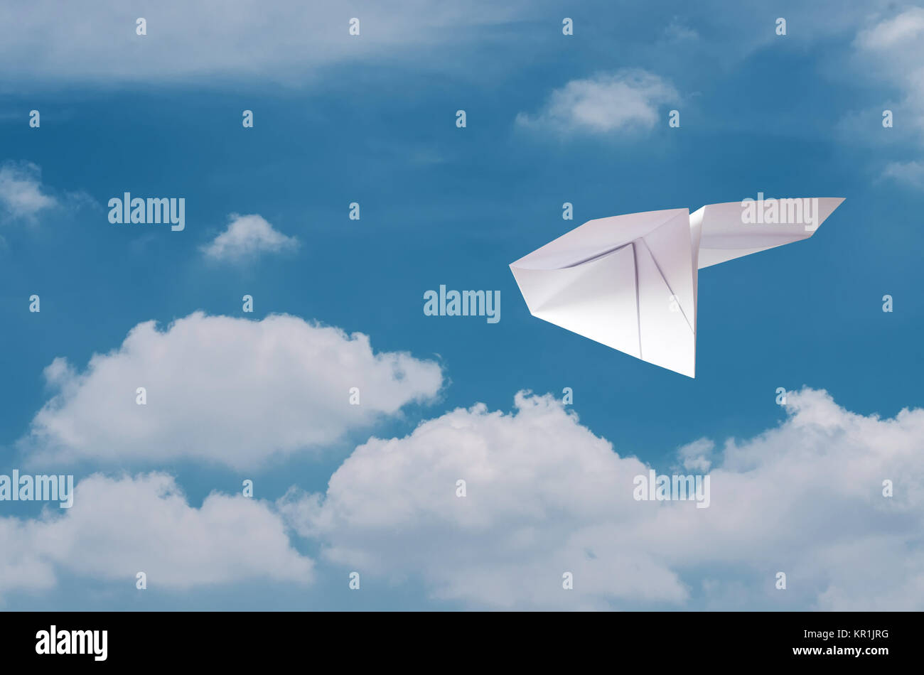 Papierflieger fliegen über den Wolken mit blauem Himmel. Stockfoto