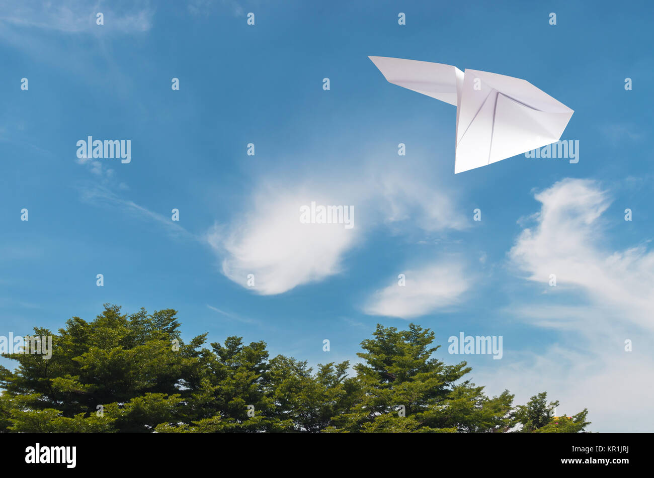 Papier Flugzeug fliegen über Baum, Wolke mit blauem Himmel. Stockfoto