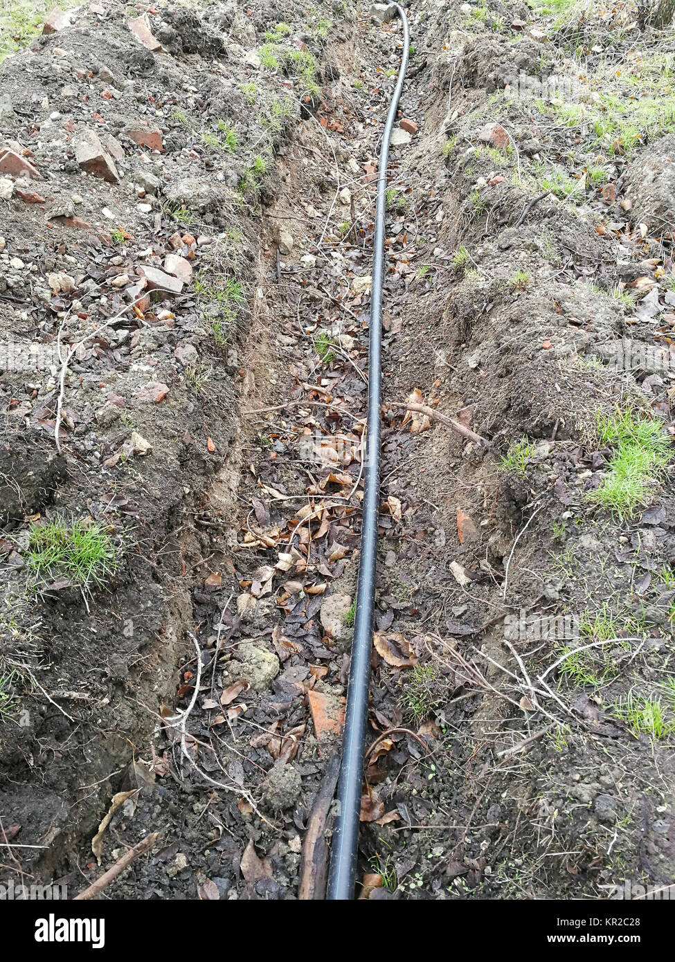 Festlegung der Sprinkleranlage der Pipeline in den Boden Gräben für die unterirdische Bewässerung, Bewässerungsanlage, land Stadtwerke in den späten Herbst im Park Stockfoto