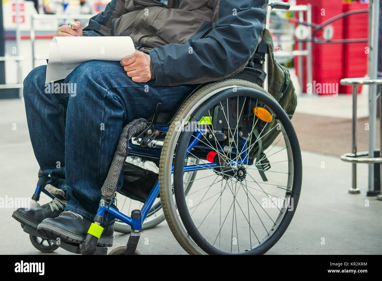 Kein Gesicht behinderte, behinderte Person auf Rädern Stuhl füllt das Formular leer oder macht eine Einkaufsliste auf dem Markt. Selektive konzentrieren. Platz für Text Stockfoto