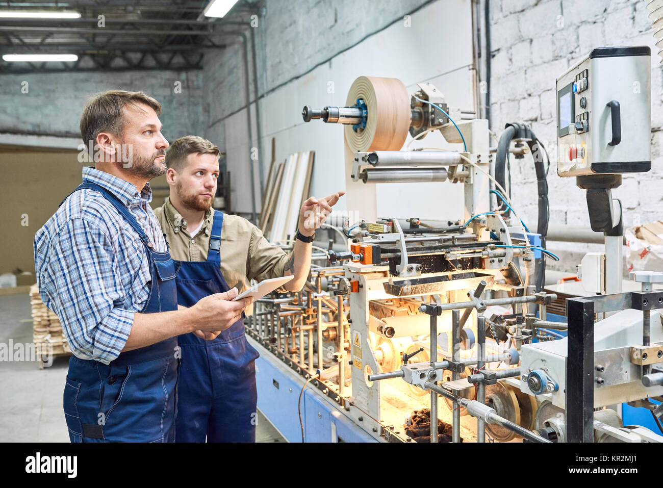 Arbeitnehmer mit modernen Maschinen im Werk Stockfoto