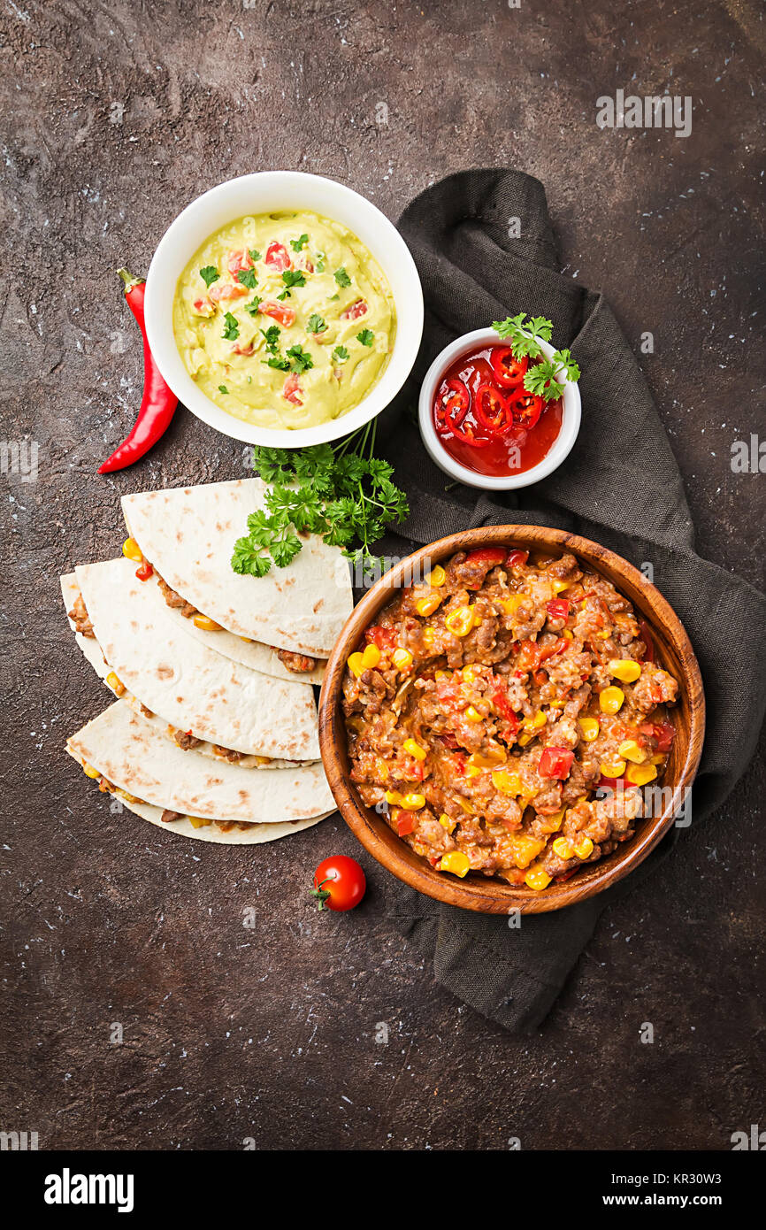Hausgemachtes Rindfleisch mexikanische Fajitas mit Tortilla und Guacamole und Salsa Saucen auf schwarzen Hintergrund, Ansicht von oben Stockfoto