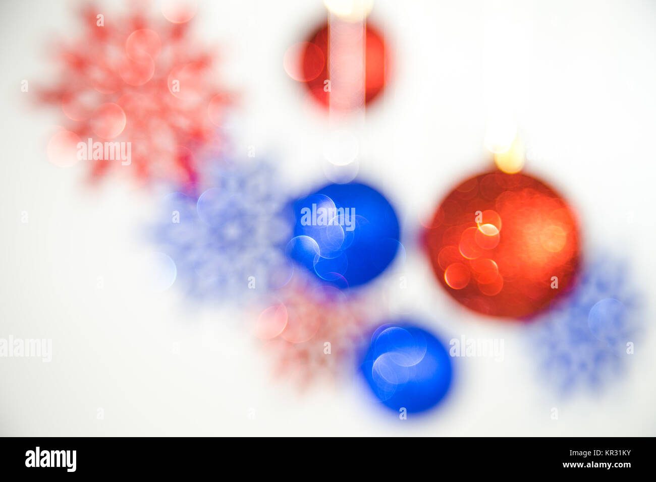 Festliche Weihnachten defokussierten Hintergrund. Neues Jahr unscharf blaue und rote Farben brillant schöne Bälle und Schneeflocken hängen an Silber Seile isoliert Stockfoto
