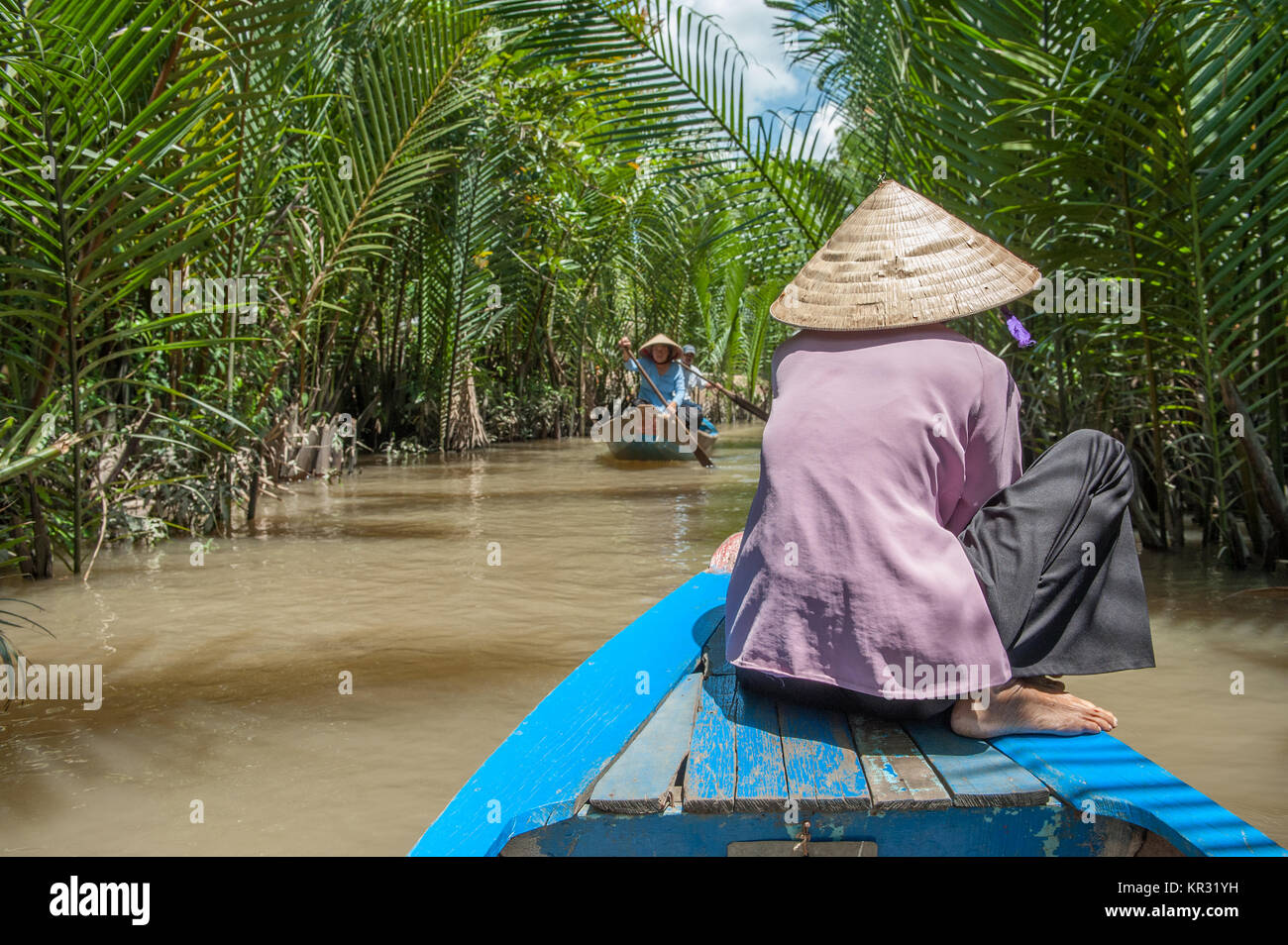 Vietnamesin Paddeln ein traditionelles Boot im Mekong Delta in Ben Tre Insel. Der Fluss Mekong ist eine wichtige Route für den Transport im Südosten Stockfoto