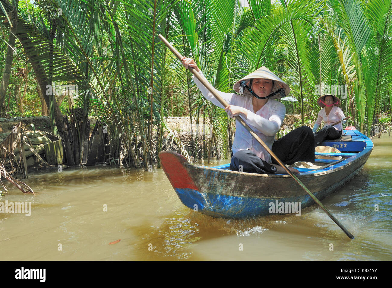Vietnamesin Paddeln ein traditionelles Boot im Mekong Delta in Ben Tre Insel. Der Fluss Mekong ist eine wichtige Route für den Transport im Südosten Stockfoto