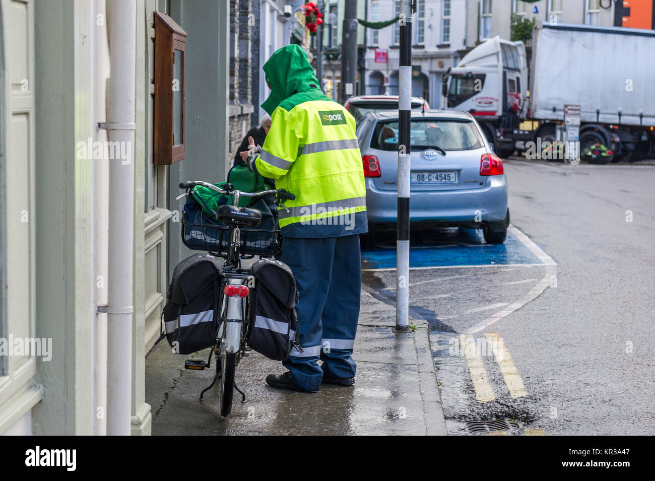 Briefträger der Post die Buchstaben auf einem Fahrrad in Skibbereen, West Cork, Irland. Stockfoto