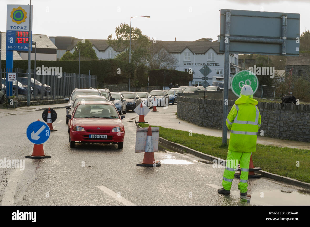 Arbeiter mit einem Stopp und Zeichen Verkehr Controlling bei Straßenarbeiten in Skibbereen, Irland mit Kopie Raum gehen. Stockfoto