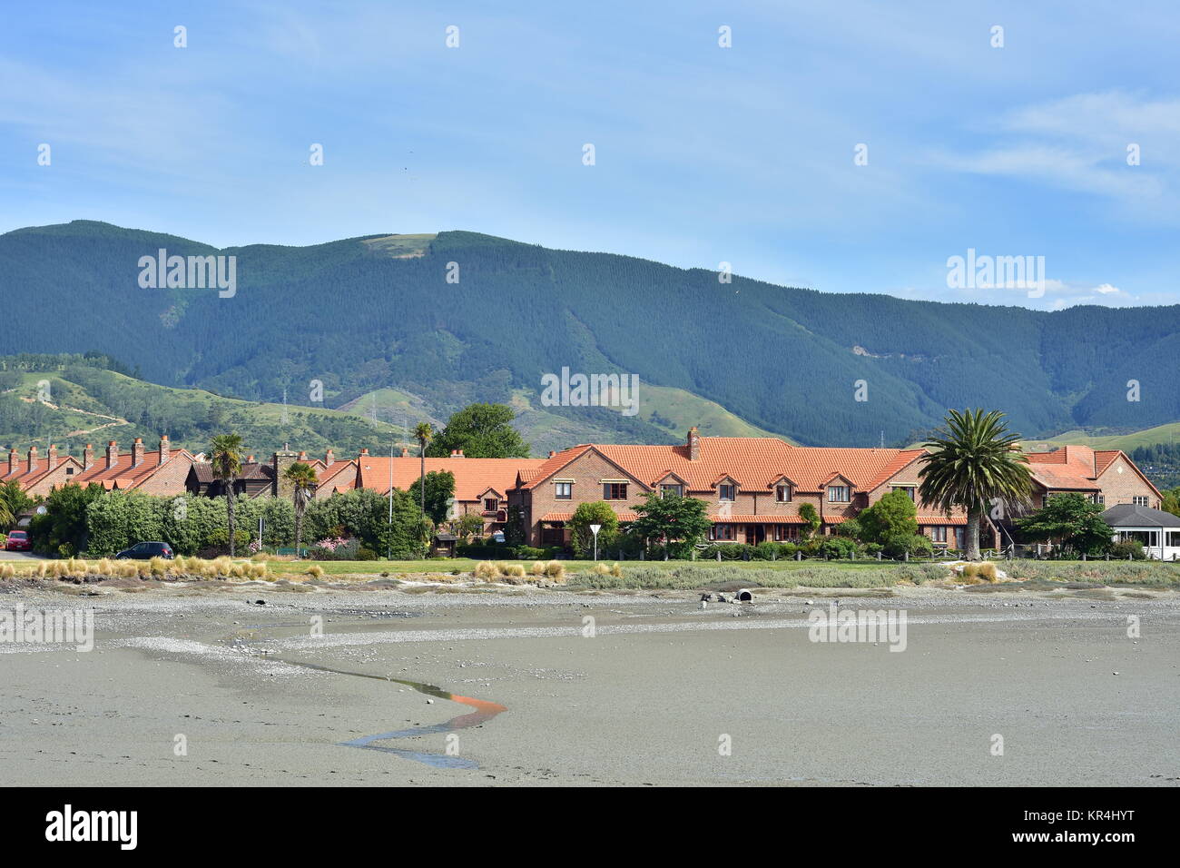 Ebbe um Monaco Halbinsel in Nelson, schlammigen Ufer mit Hotel Grand Mercure und Berge im Hintergrund. Stockfoto