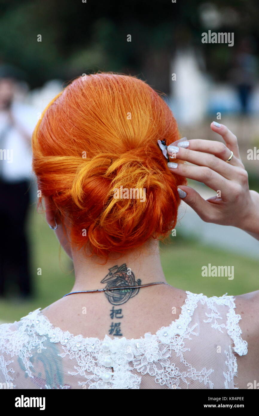 Redheadd Braut mit einem Hals tattoo bei der Hochzeit Stockfoto