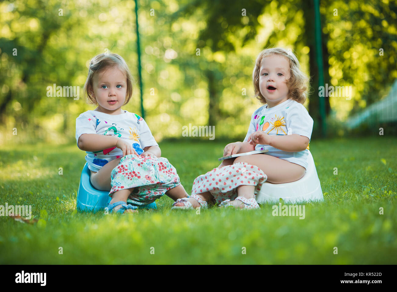 Die beiden baby wenig Mädchen kopfüber hängend Stockfoto