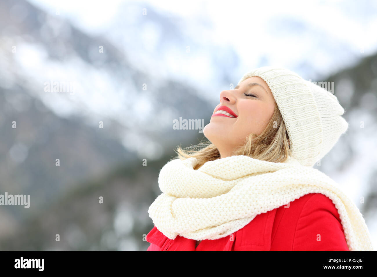 Glückliche Frau atmet tief die frische Luft im Winter auf Urlaub in die schneebedeckten Berge Stockfoto