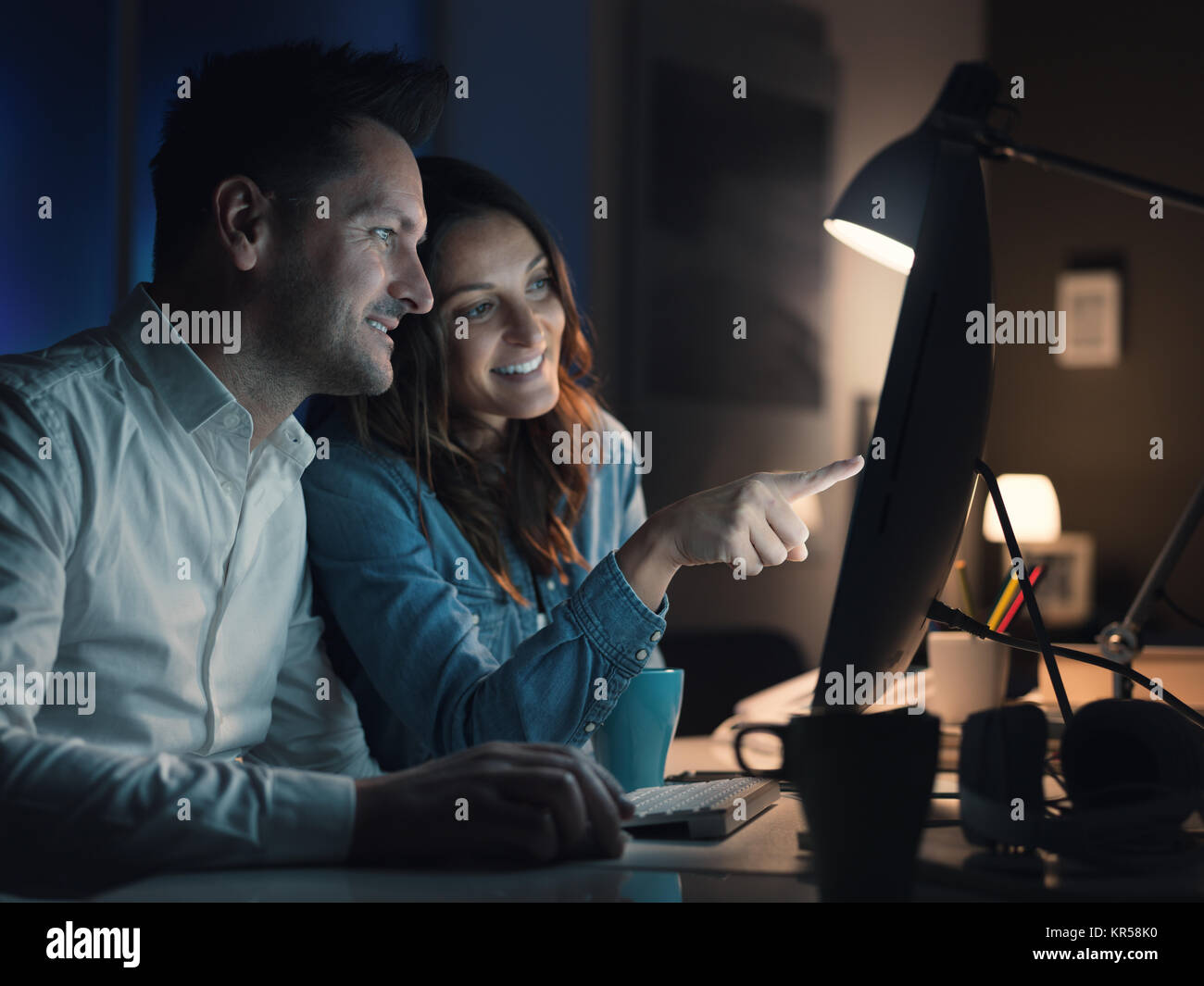 Glückliches Paar online miteinander zu Hause, Sie sind Videos und Filme spät in der Nacht beobachten, die Frau ist, die auf dem Bildschirm Stockfoto
