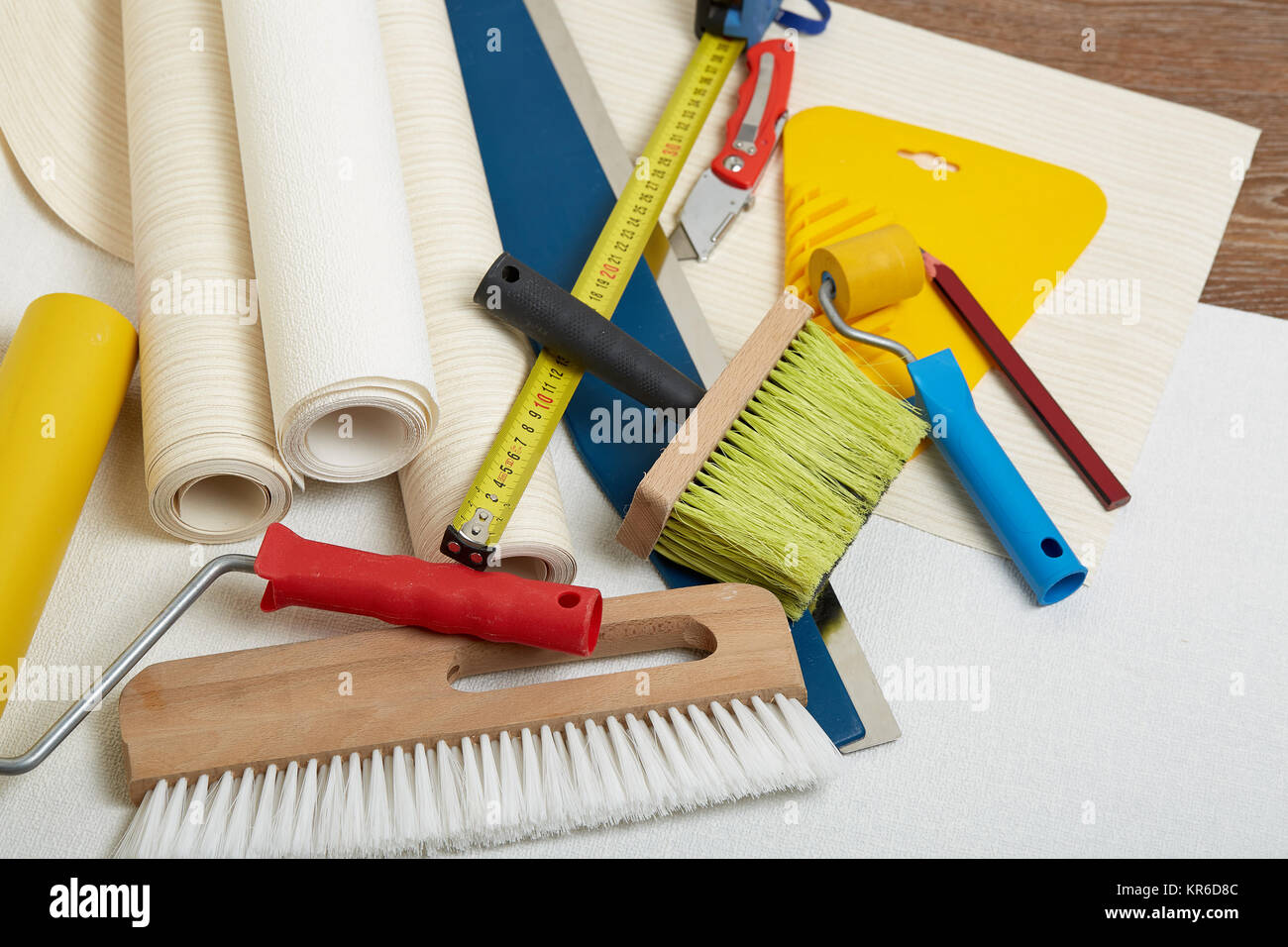 Rollen von Tapeten und verschiedene Werkzeuge zum Tapezieren. Stockfoto