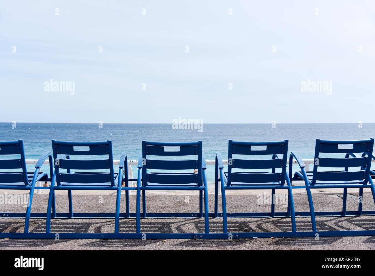 Die charakteristischen blauen Stühlen mit Blick auf das Mittelmeer an der berühmten Promenade des Anglais in Nizza an der französischen Riviera, Frankreich Stockfoto