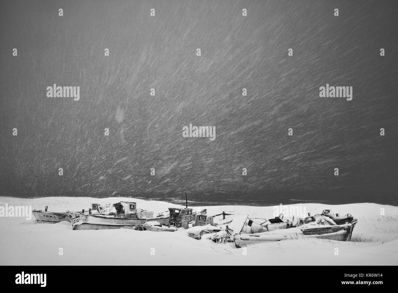 Fischerboote liegen auf trockenem Land in Schnee und Eis im Winter abgedeckt. Stockfoto