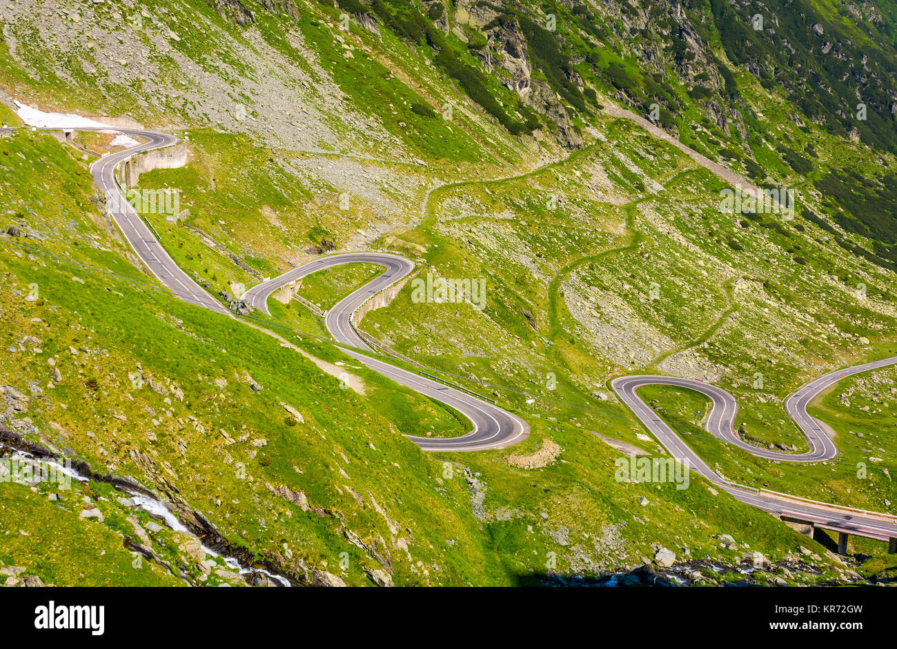 Transfagarasan Straße in den rumänischen Bergen. wicklung Serpentine unter den grasbewachsenen Hügeln an einem sonnigen Morgen Stockfoto