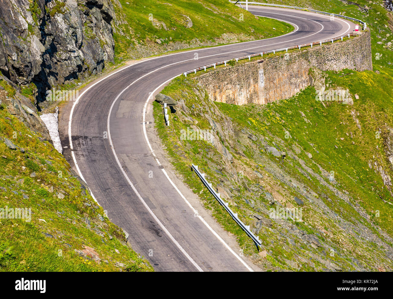 Transfagarasan Straße in den rumänischen Bergen. wicklung Serpentine unter den grasbewachsenen Hügeln an einem sonnigen Morgen Stockfoto