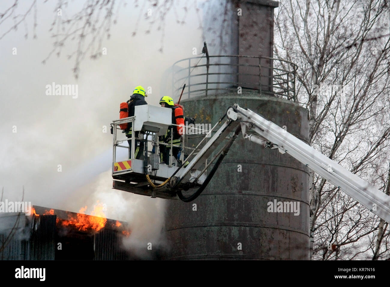 SALO, Finnland - 16. FEBRUAR 2014: die Brandbekämpfung Löschmittel Flammen auf einem hydraulischen Kran Plattform an der Salo Zementwerk, das in Brand Stockfoto