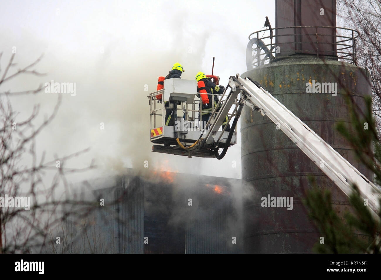 SALO, Finnland - 16. FEBRUAR 2014: Feuerwehrmänner löschen Feuer auf einem hydraulischen Kran Plattform an der Salo Zementwerk. Stockfoto