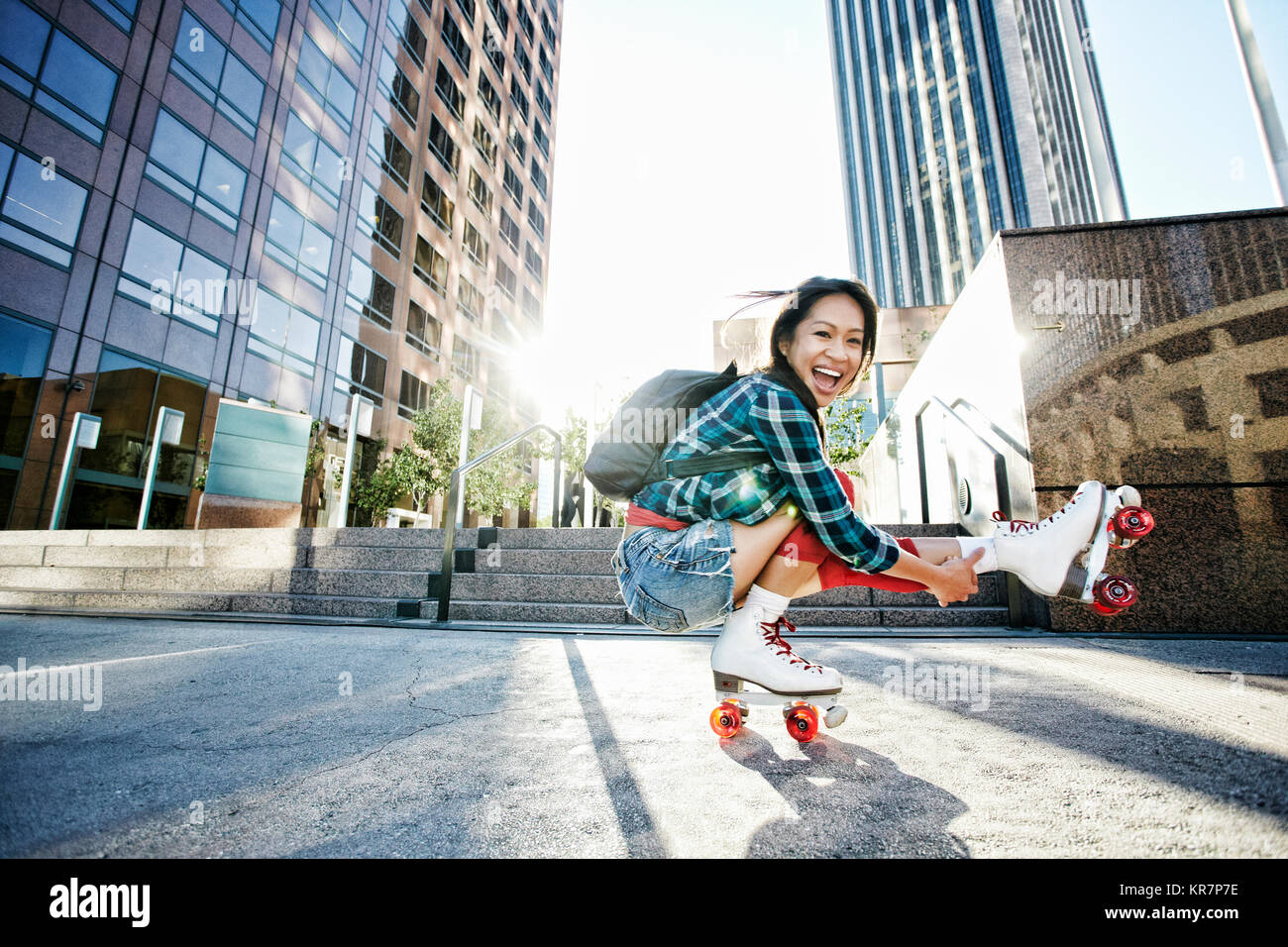 Asiatische Frau rollerskating in der Stadt auf ein Bein Stockfoto