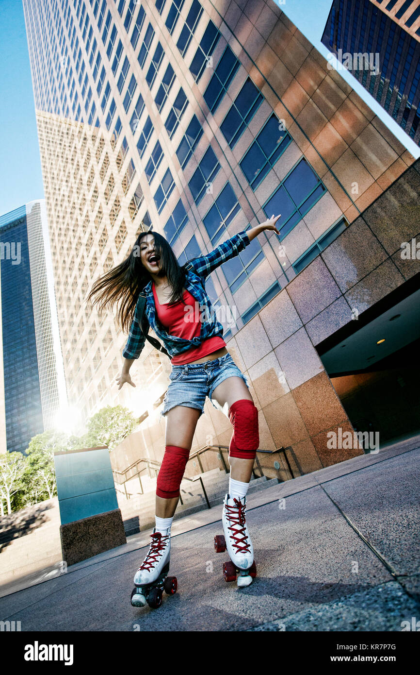 Aufgeregt asiatische Frau rollerskating in Stadt Stockfoto