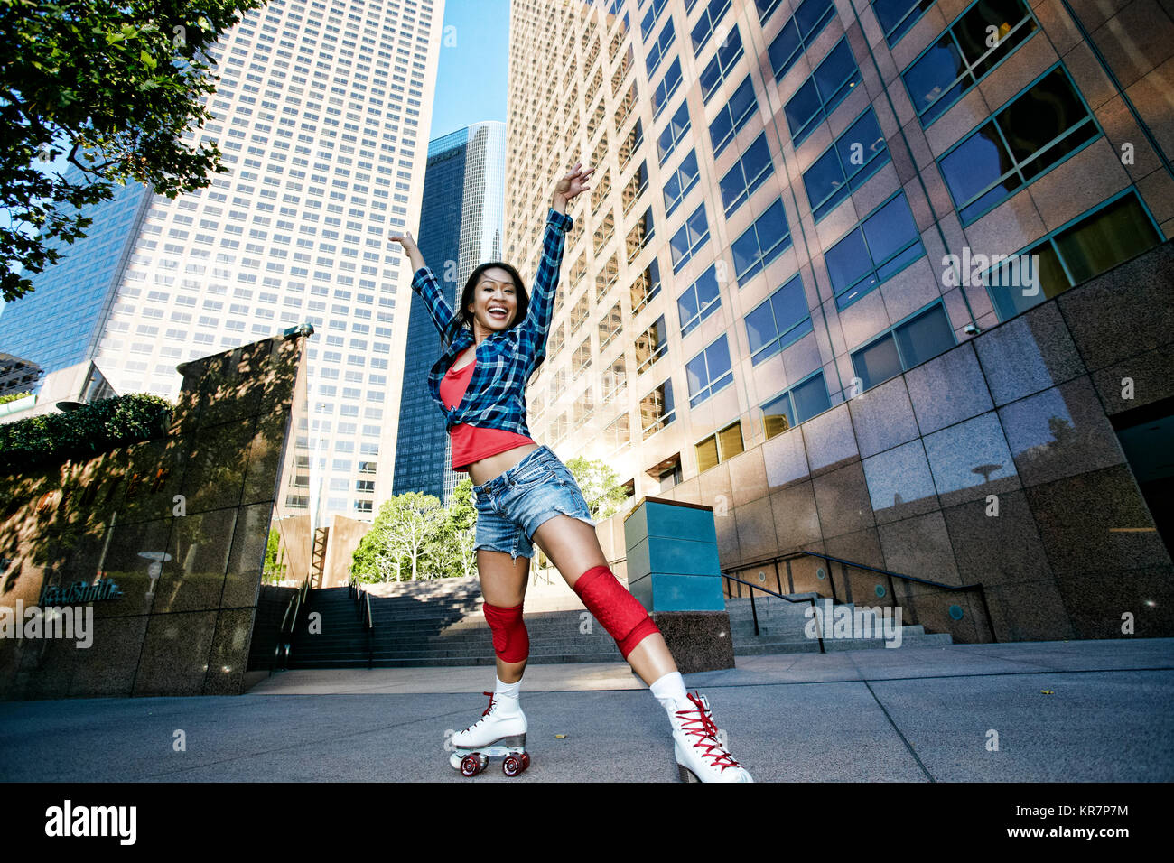 Aufgeregt asiatische Frau rollerskating in Stadt Stockfoto