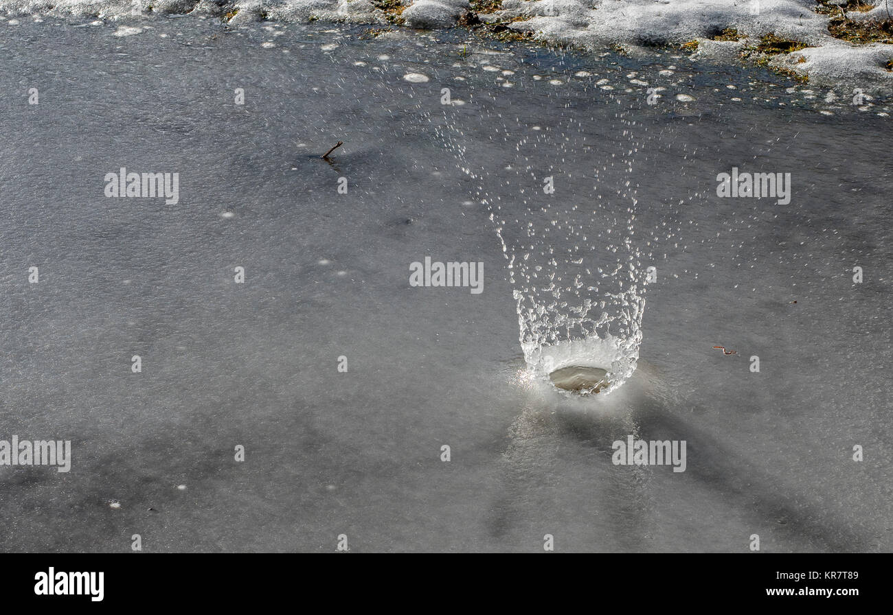 Ein Stein auf dem gefrorenen Pfütze geworfen Stockfoto