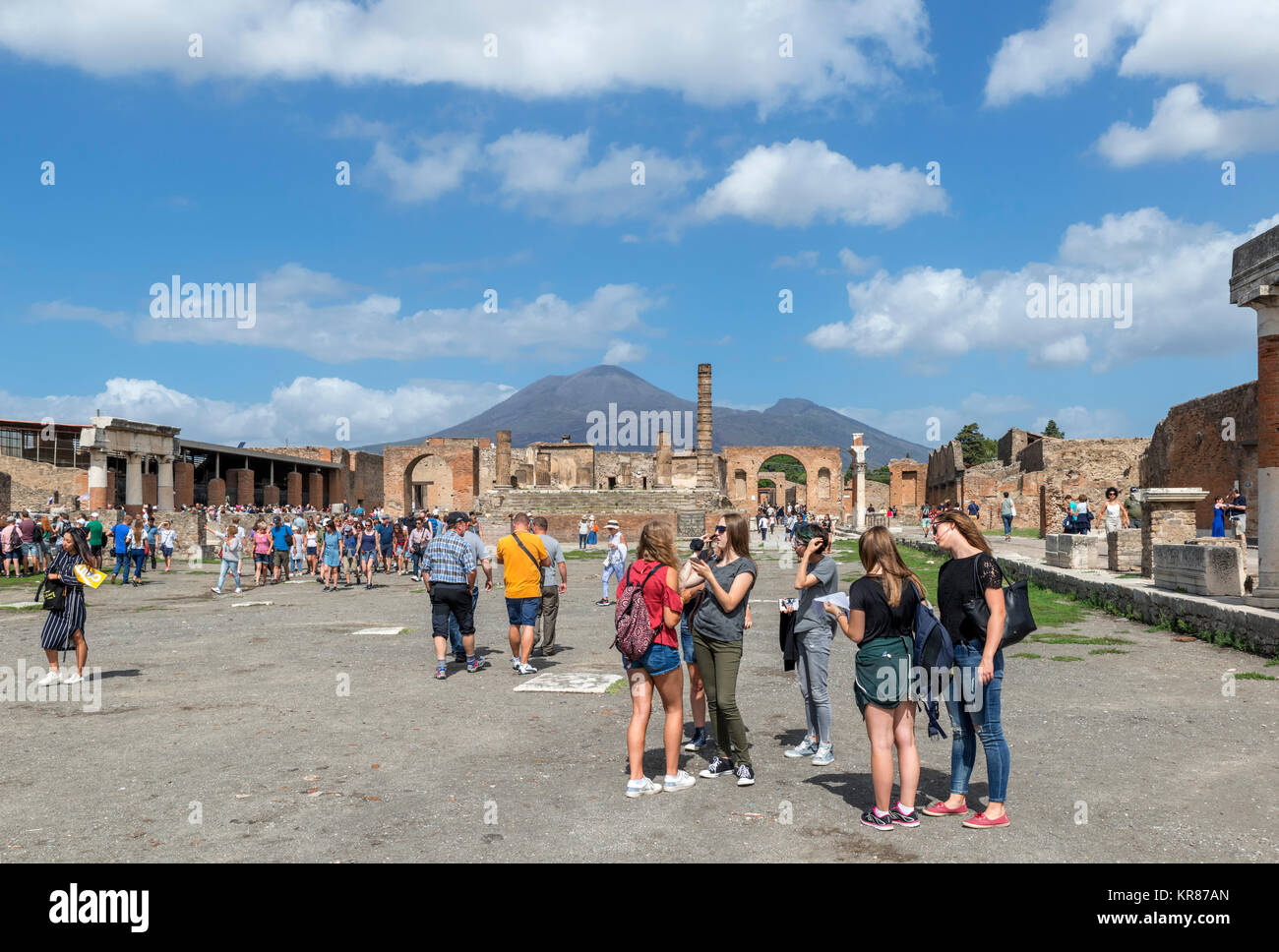 Touristen in die Ruinen des Forum Romanum in Pompeji (Pompei) mit Blick auf den Vesuv im Hintergrund, Neapel, Kampanien, Italien Stockfoto