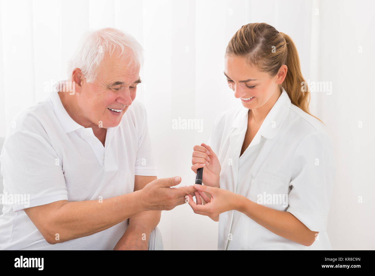 Arzt mit lanzettfischchens am Finger des Patienten Stockfoto