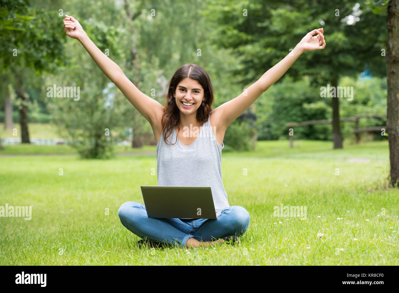 Neugierige junge Frau mit Laptop Stockfoto