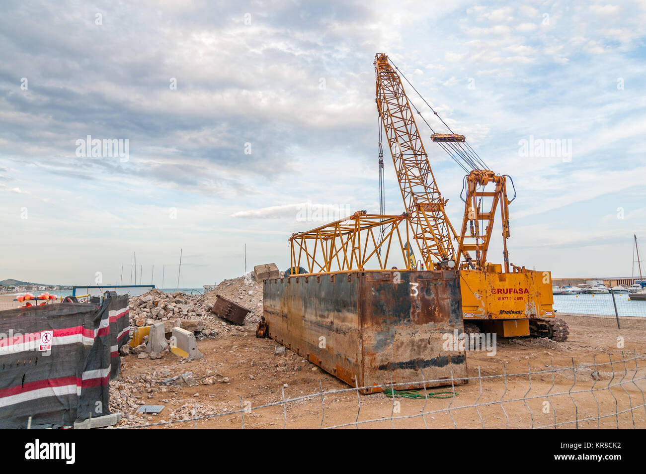 Gelbe Baukran amking arbeitet im Hafen, Coma-ruga, Tarragona, Katalonien, Spanien Stockfoto