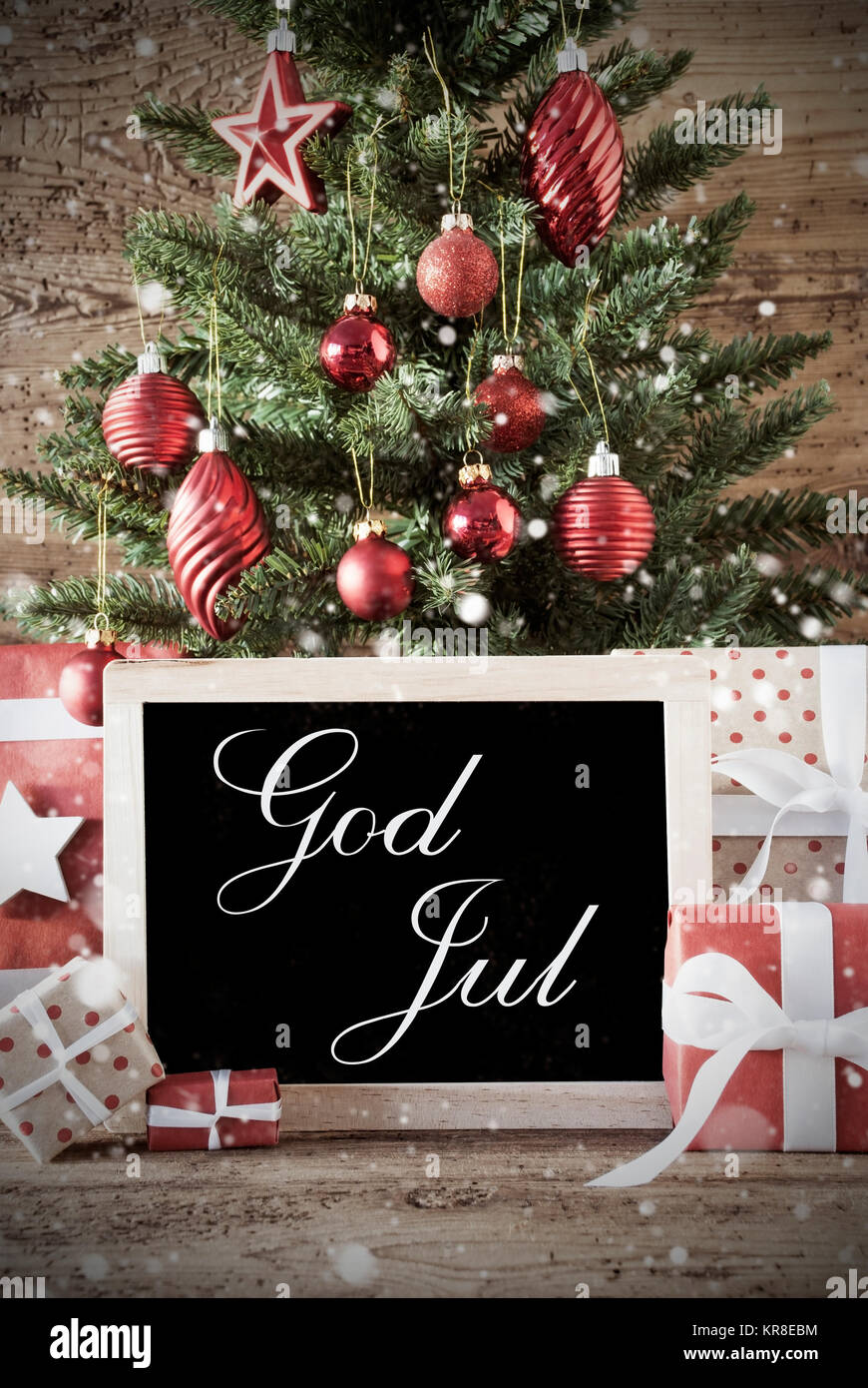 Nostalgische Weihnachten Karte für Seasons Greetings. Weihnachtsbaum mit Kugeln. Geschenke oder präsentiert In der Vorderseite des Holz- Hintergrund. Schiefertafel mit schwedischen Text Gott Aug bedeutet Frohe Weihnachten Stockfoto