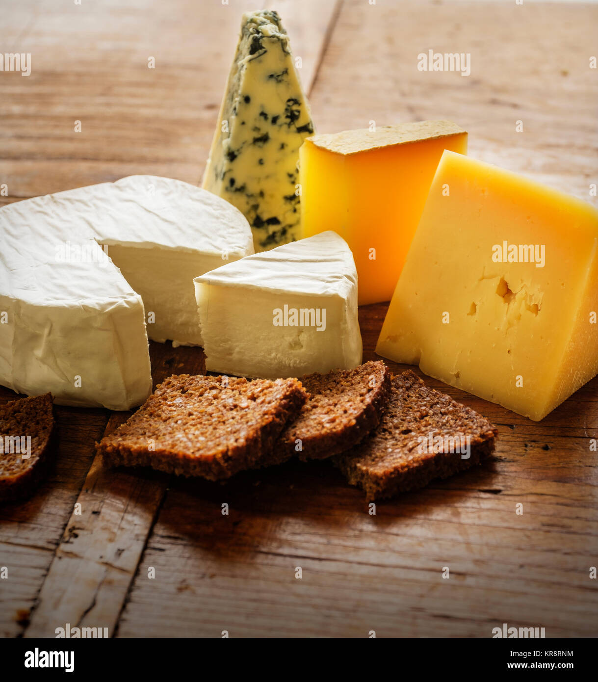 Verschiedene Käsesorten und Scheiben Brot Stockfoto