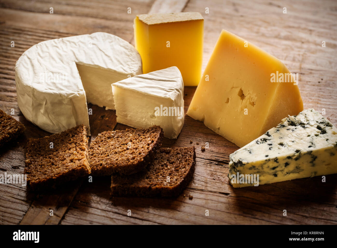 Verschiedene Käsesorten und Scheiben Brot Stockfoto