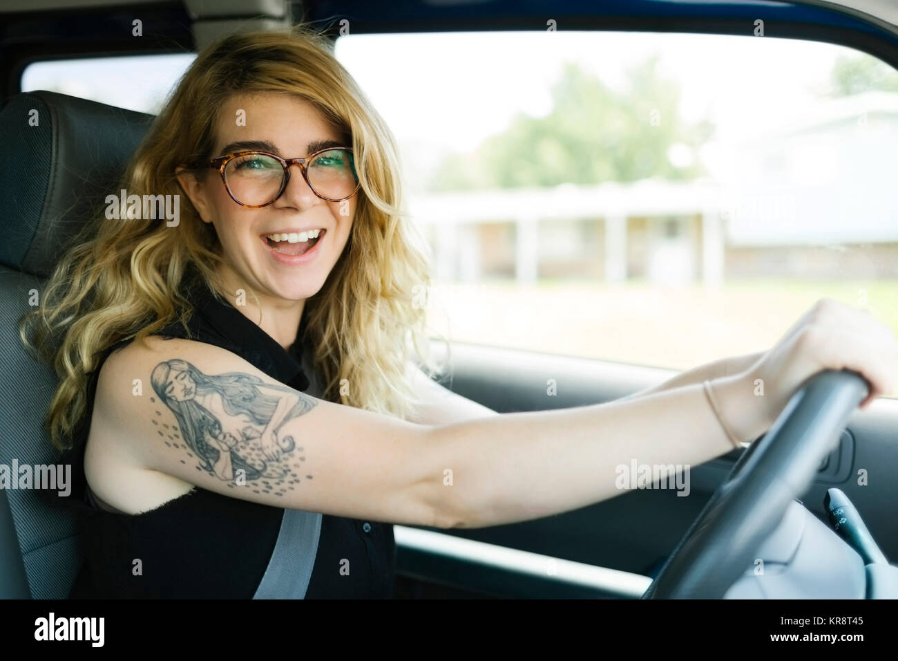 Frau Autofahren und Lachen Stockfoto