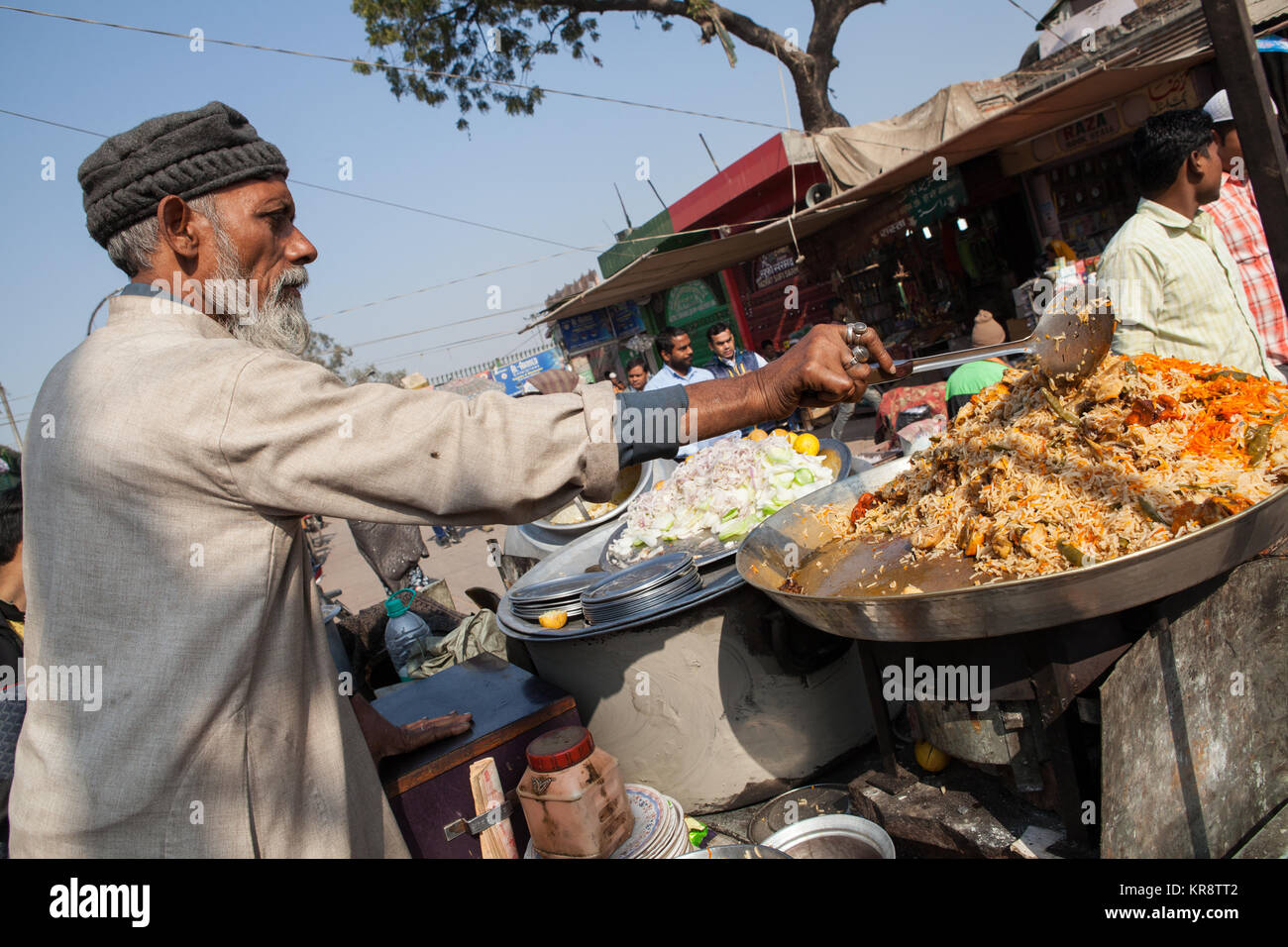 Ein muslimischer Mann bereitet eine Portion chicken Biryani in der Altstadt von Delhi, Indien Stockfoto