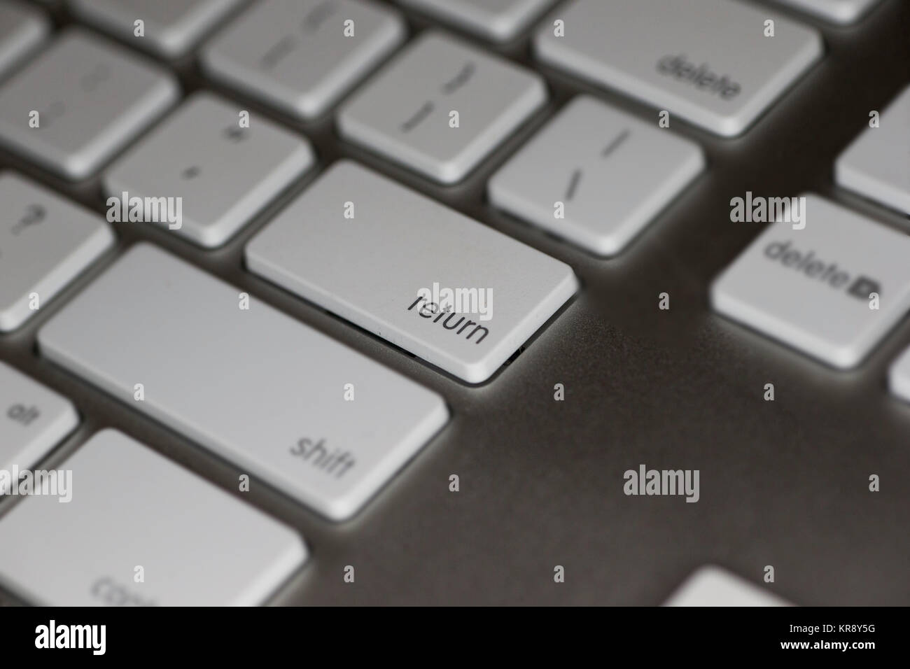 Nahaufnahme der RETURN-Taste auf dem Computer Tastatur mit weißen Tasten auf dunklem Hintergrund Stockfoto