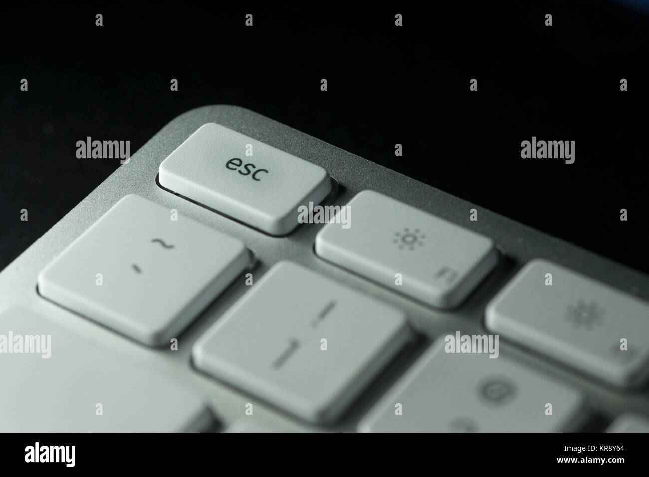 Nahaufnahme der Esc-Taste auf der Tastatur des Computers mit weißen Tasten auf dunklem Hintergrund Stockfoto