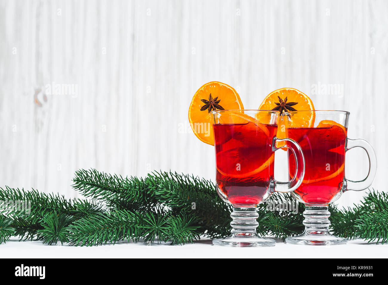 Weihnachten Glas Rotwein Glühwein auf Tabelle mit Zimt Reisig, Zweige der Weihnachtsbaum auf weißem Holz- Hintergrund. Freier Speicherplatz Stockfoto