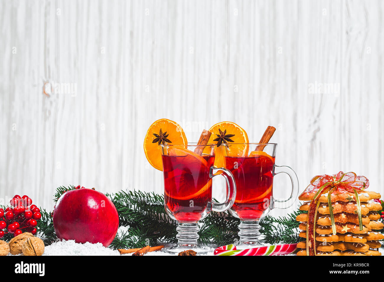 Weihnachten Glas Rotwein Glühwein auf Tabelle mit Zimt Reisig, Zweige von Weihnachten, Baum, Schnee, Lebkuchen, Kegel, Süßigkeiten, Neues Jahr Dekorationen auf Stockfoto