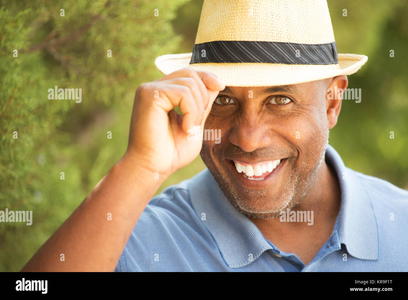 Afrikanische amerikanische Mann seinen Hut außen kippen. Stockfoto