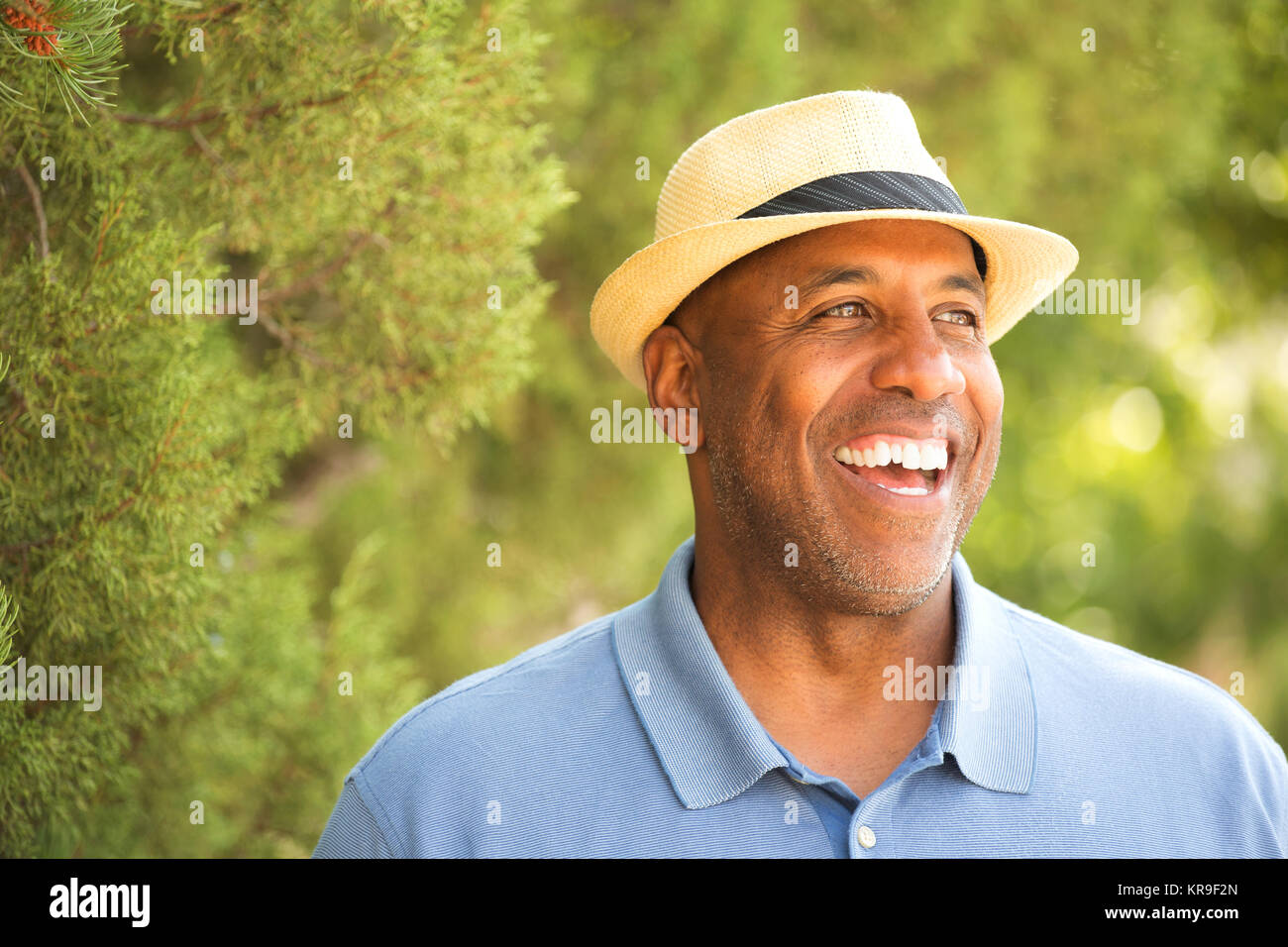 Afrikanische amerikanische Mann seinen Hut außen kippen. Stockfoto