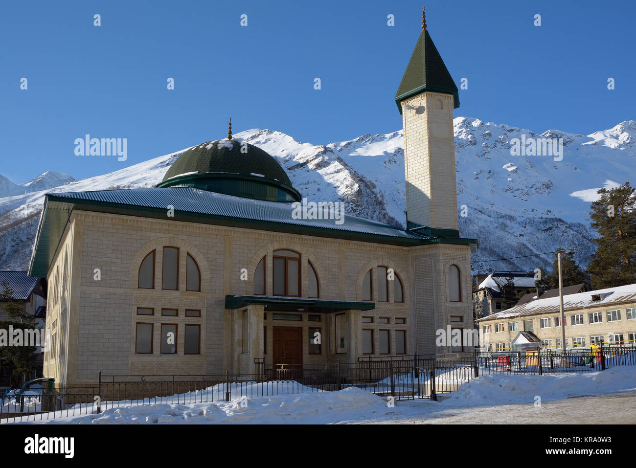 Moschee auf dem Hintergrund der schneebedeckten Berge Stockfoto