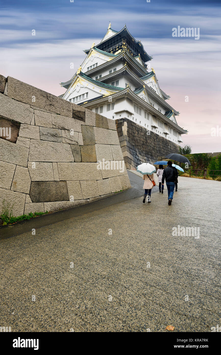 Menschen mit Sonnenschirmen am Schloss Osaka historische Sicht, Osakajo auf einem schönen Misty regnerischen Morgen bei Sonnenaufgang. Osaka, Japan 2017 Stockfoto